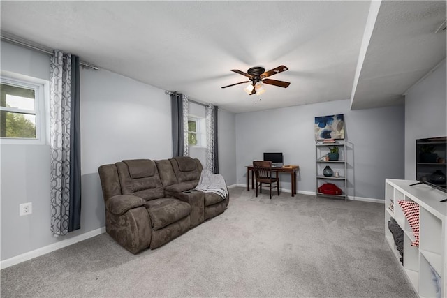 living room with baseboards, a ceiling fan, and carpet flooring