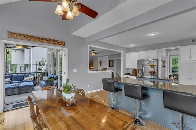 dining room with baseboards, a ceiling fan, light wood-style flooring, and visible vents