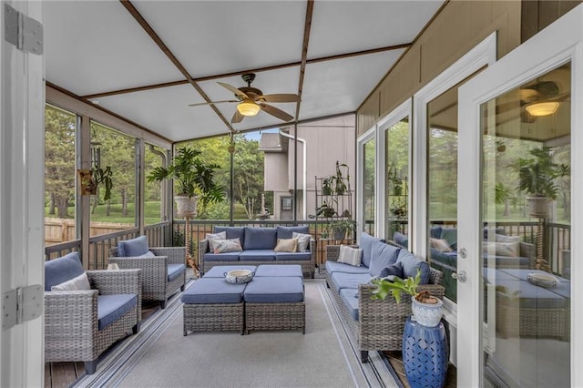sunroom / solarium featuring a ceiling fan and an outdoor living space