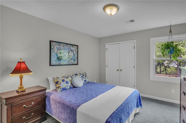bedroom featuring carpet floors, a textured ceiling, baseboards, visible vents, and a closet
