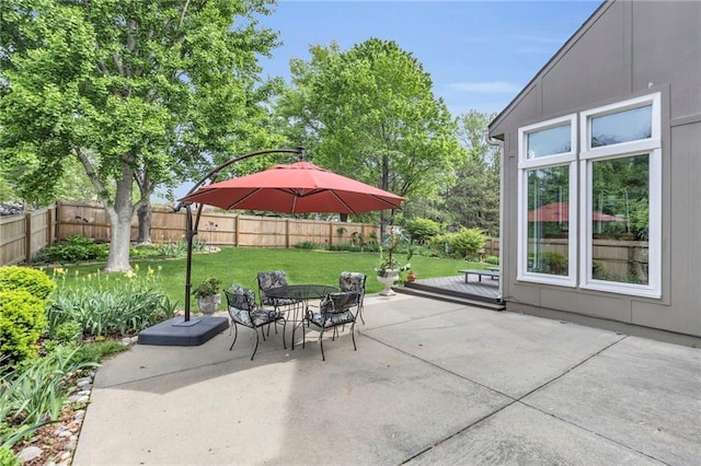 view of patio featuring outdoor dining area, a fenced backyard, and a wooden deck
