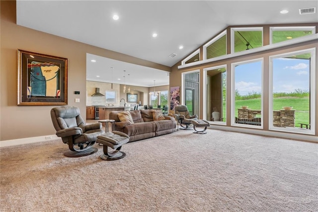 carpeted living room with visible vents, recessed lighting, baseboards, and high vaulted ceiling