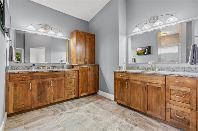 bathroom with baseboards, two vanities, and a sink