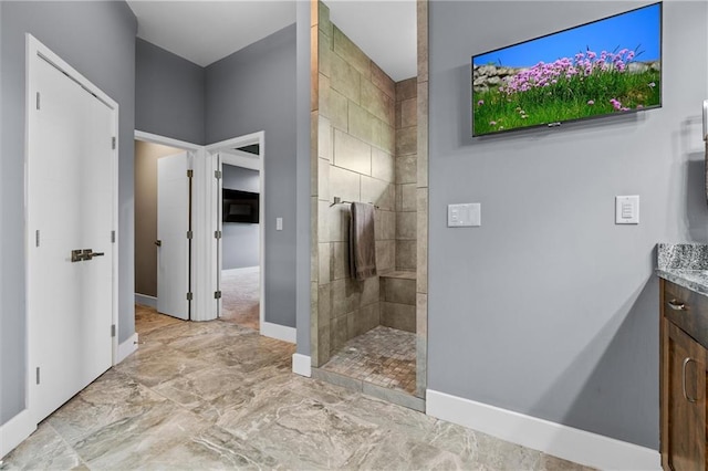 bathroom with baseboards, marble finish floor, walk in shower, and vanity