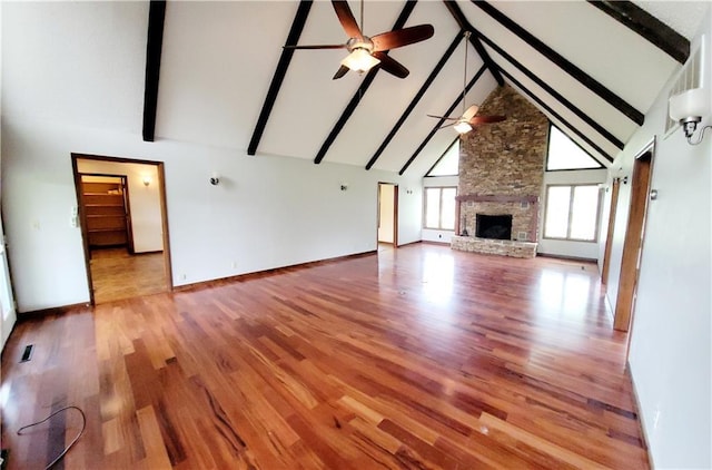 1620 Neosho St, Humboldt, KS 66748 - unfurnished living room featuring beam ceiling, wood finished floors, a ceiling fan, and high vaulted ceiling