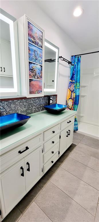 1620 Neosho St, Humboldt, KS 66748 - full bathroom with a shower with curtain, tile patterned flooring, decorative backsplash, and vanity