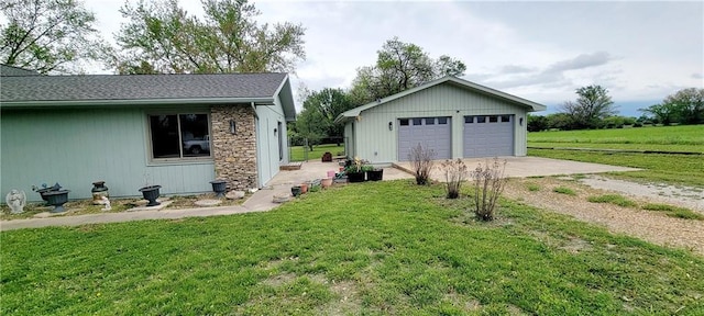 1620 Neosho St, Humboldt, KS 66748 - exterior space with an outbuilding, a detached garage, stone siding, and a front yard