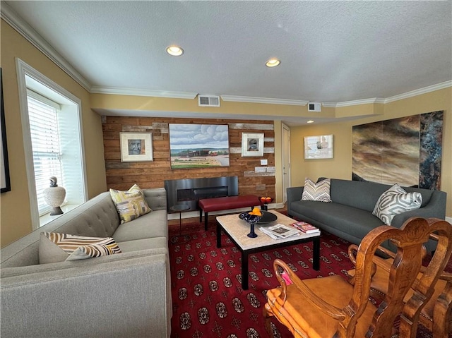 living room with carpet floors, ornamental molding, a textured ceiling, and visible vents