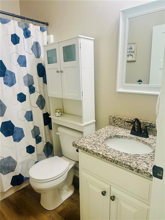 full bathroom with wood finished floors, toilet, a shower with curtain, and vanity