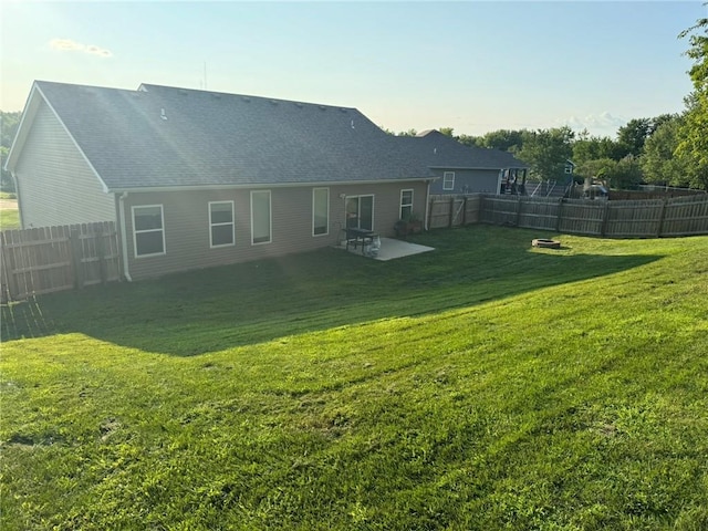 back of property with a fenced backyard and a yard
