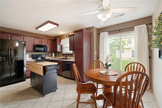 kitchen with light countertops, a ceiling fan, black appliances, and a wealth of natural light