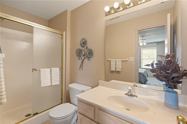 ensuite bathroom with vanity, a shower stall, toilet, and visible vents