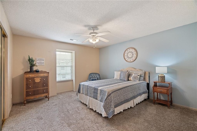 bedroom with carpet floors, a ceiling fan, a textured ceiling, and visible vents
