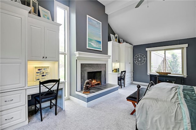living area with a wealth of natural light, a ceiling fan, vaulted ceiling, and a premium fireplace
