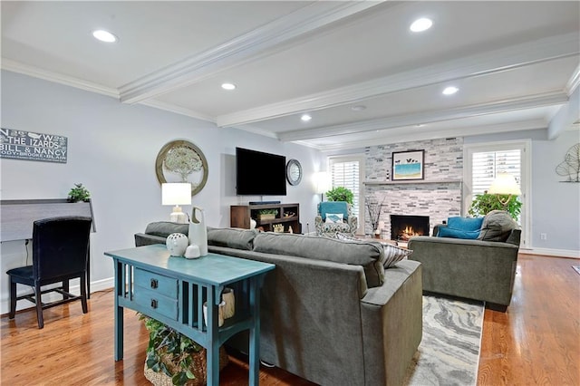 living area featuring crown molding, a large fireplace, beam ceiling, and wood finished floors