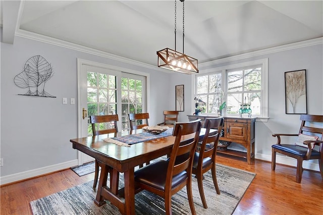 dining room featuring crown molding, baseboards, and light wood-style flooring