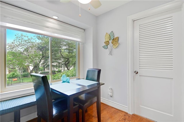 dining space with baseboards, light wood-style flooring, and ceiling fan