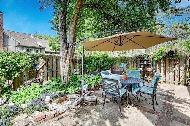 view of patio with outdoor dining area and a fenced backyard