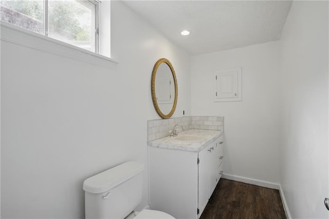 5900 Westridge Rd, Kansas City, MO 64133 - half bathroom featuring toilet, vanity, baseboards, wood finished floors, and recessed lighting