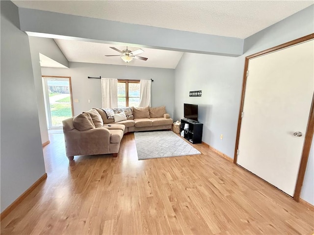 living area with light wood-type flooring, a ceiling fan, baseboards, and lofted ceiling