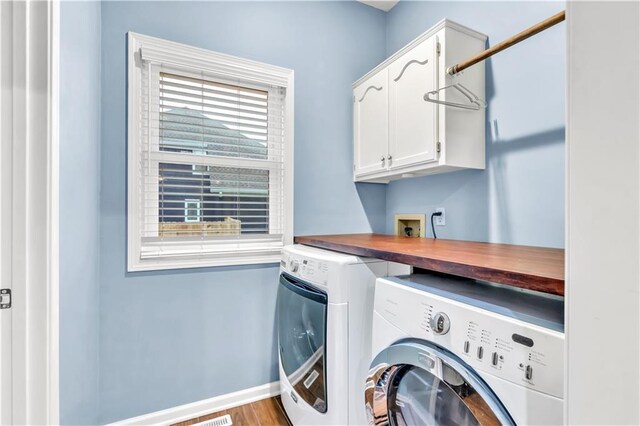 laundry room featuring baseboards, washer and clothes dryer, and cabinet space