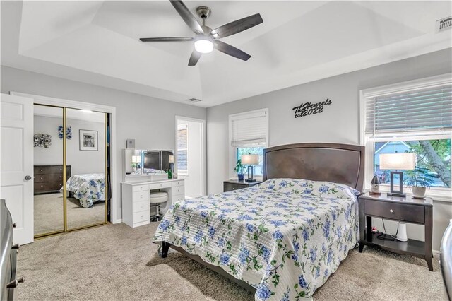 bedroom with carpet floors, a closet, visible vents, and multiple windows
