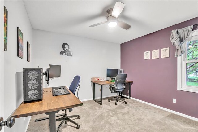 carpeted home office featuring baseboards and ceiling fan
