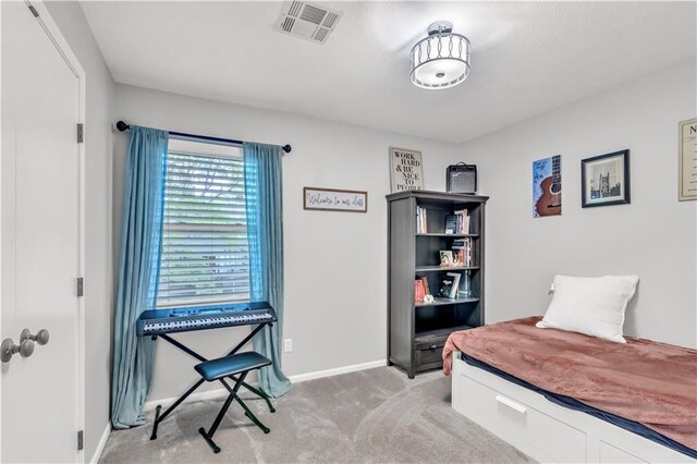 carpeted bedroom featuring baseboards and visible vents