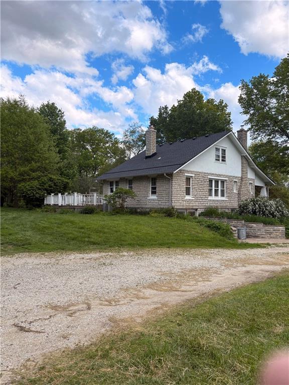 exterior space featuring a lawn, driveway, and a chimney