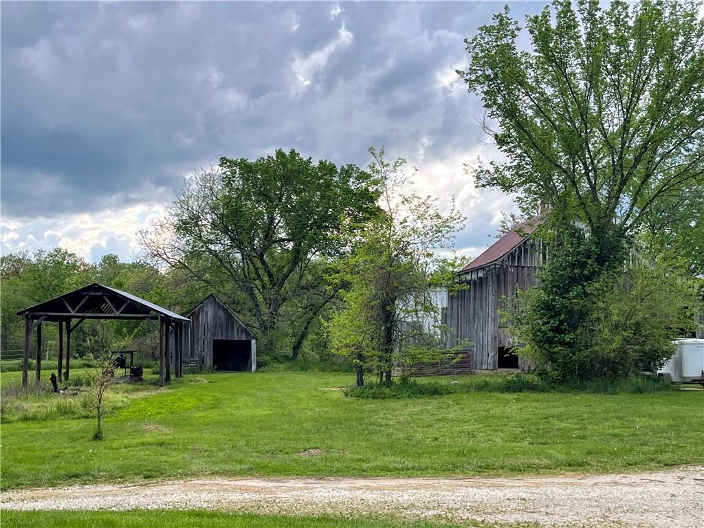 view of yard featuring a garage, an outbuilding, and a pole building