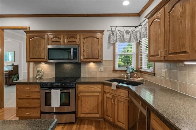12606 Slater St, Overland Park, KS 66213 - kitchen with appliances with stainless steel finishes, ornamental molding, dark countertops, wood finished floors, and brown cabinets