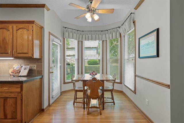 12606 Slater St, Overland Park, KS 66213 - dining area with light wood finished floors, a ceiling fan, a textured ceiling, and ornamental molding