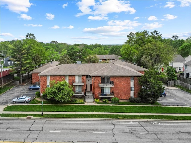 8215 Santa Fe Dr Unit 10, Overland Park, KS 66204 - bungalow with roof with shingles, brick siding, fence, uncovered parking, and a front lawn