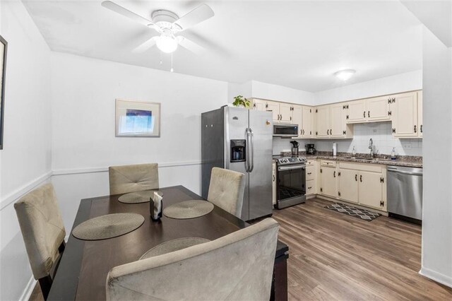 8215 Santa Fe Dr Unit 10, Overland Park, KS 66204 - kitchen with ceiling fan, appliances with stainless steel finishes, a sink, decorative backsplash, and wood finished floors
