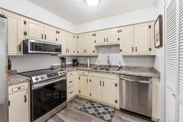 8215 Santa Fe Dr Unit 10, Overland Park, KS 66204 - kitchen featuring light wood-style floors, a sink, appliances with stainless steel finishes, and tasteful backsplash