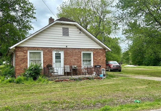 3526 Belmont Ave, Parsons, KS 67357 - rear view of property featuring a chimney, a yard, and brick siding