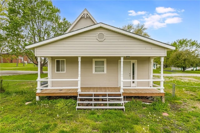 view of front of property featuring a porch, a front lawn, and fence