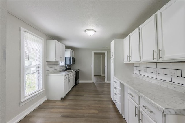 kitchen with baseboards, decorative backsplash, dark wood-style flooring, and electric stove