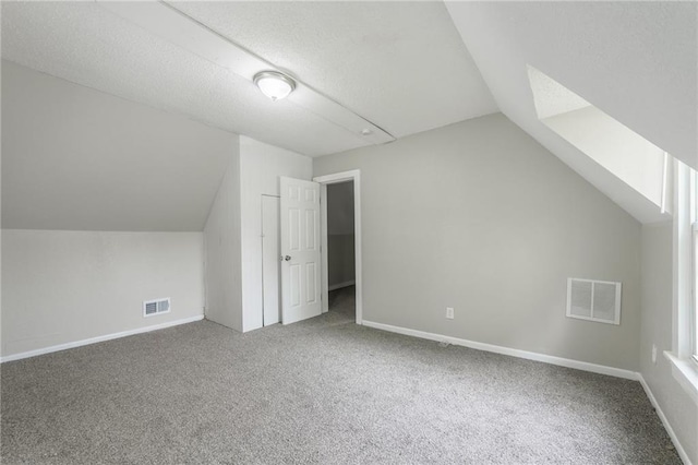 bonus room featuring carpet flooring, visible vents, and vaulted ceiling
