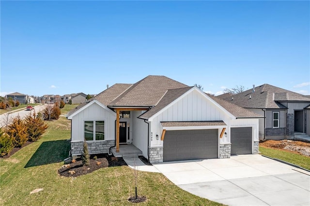 view of front of house featuring a garage, a front lawn, board and batten siding, and stone siding