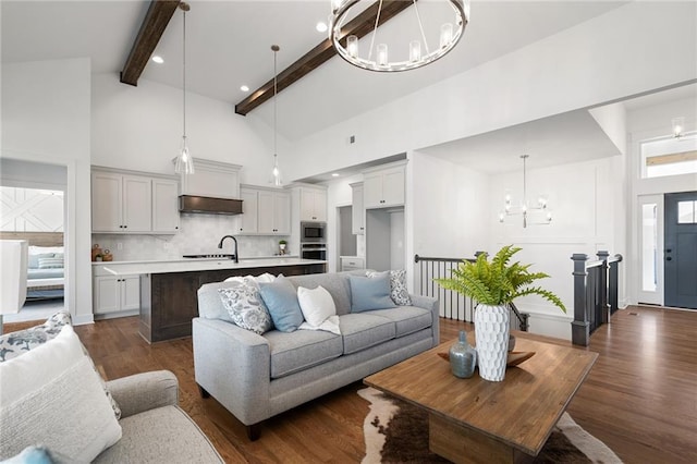 living room featuring high vaulted ceiling, a notable chandelier, beam ceiling, and dark wood-type flooring