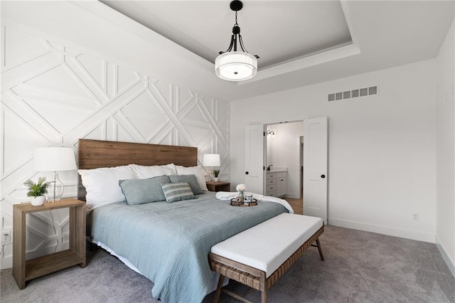 bedroom with baseboards, visible vents, light carpet, and a raised ceiling