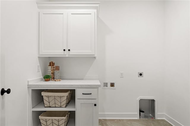 clothes washing area with electric dryer hookup, hookup for a washing machine, cabinet space, and baseboards