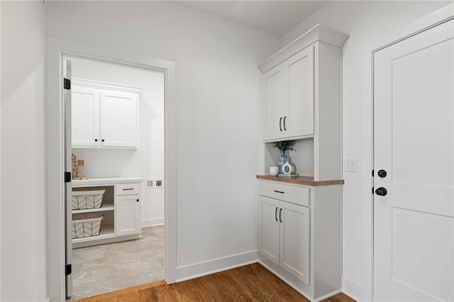 laundry area featuring baseboards and light wood-type flooring