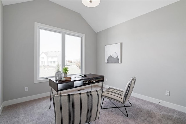 office space featuring light colored carpet, baseboards, and vaulted ceiling