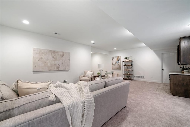 living area with recessed lighting, baseboards, visible vents, and light carpet