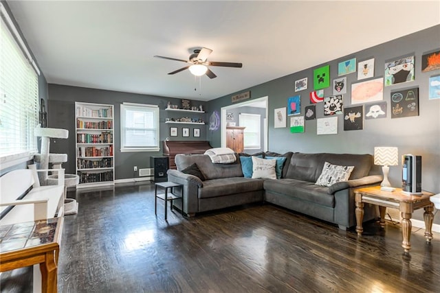 living area with a ceiling fan, wood finished floors, and baseboards