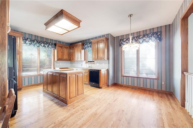 2269 SW Park Ave, Blue Springs, MO 64015 - kitchen featuring black dishwasher, wallpapered walls, light wood-style floors, light countertops, and a chandelier