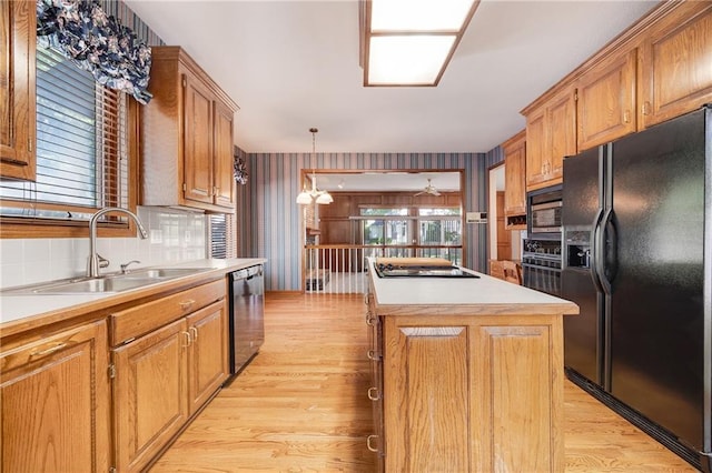 2269 SW Park Ave, Blue Springs, MO 64015 - kitchen with black appliances, a center island, light wood-style flooring, light countertops, and brown cabinetry