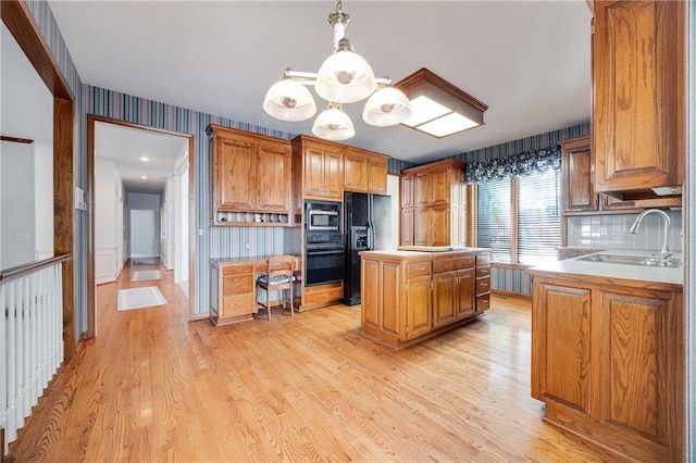 2269 SW Park Ave, Blue Springs, MO 64015 - kitchen with black appliances, a center island, light wood-type flooring, light countertops, and decorative backsplash
